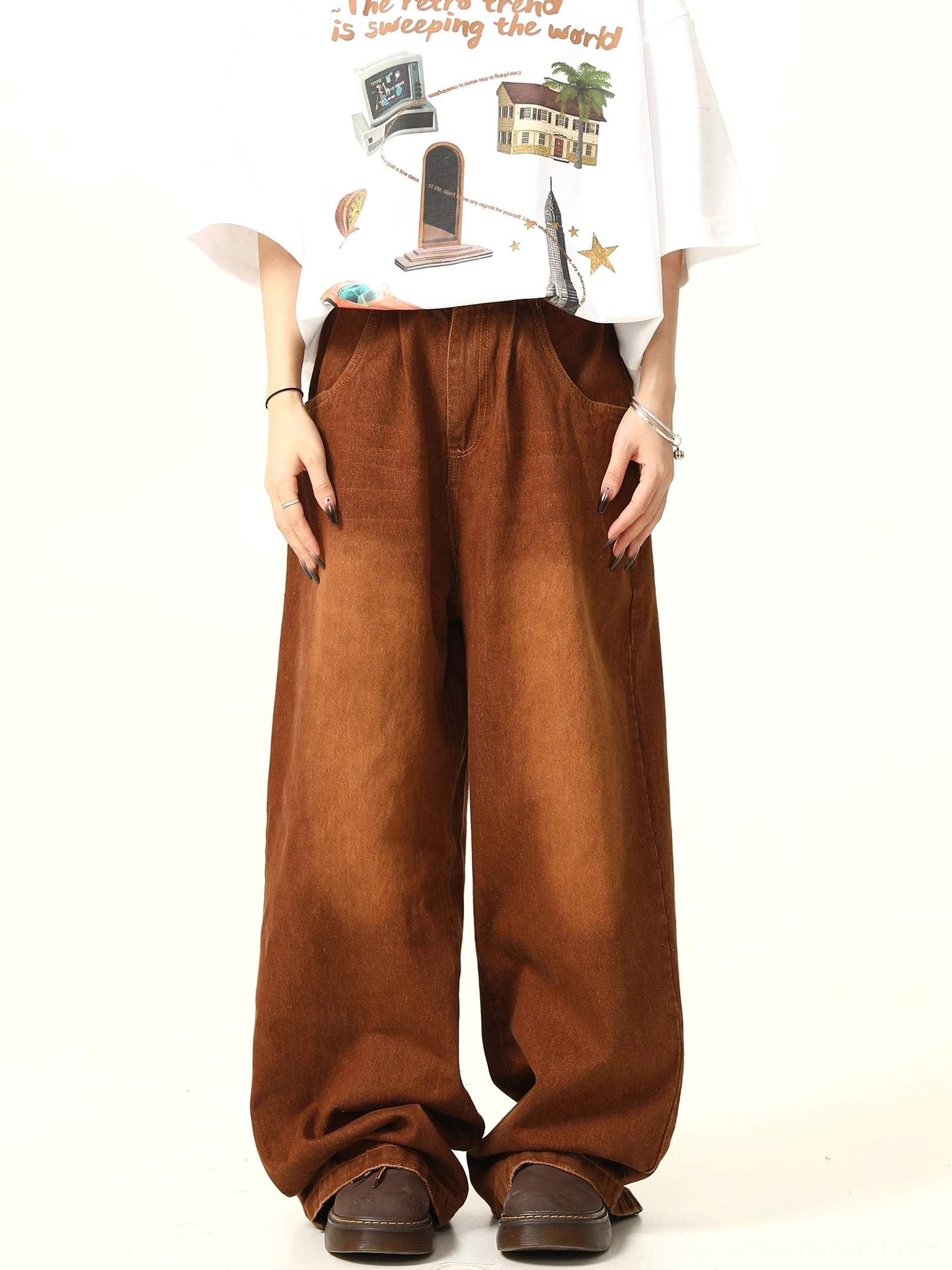 Front view of vintage washed brown wide leg denim pants styled with a graphic white T-shirt and brown leather loafers