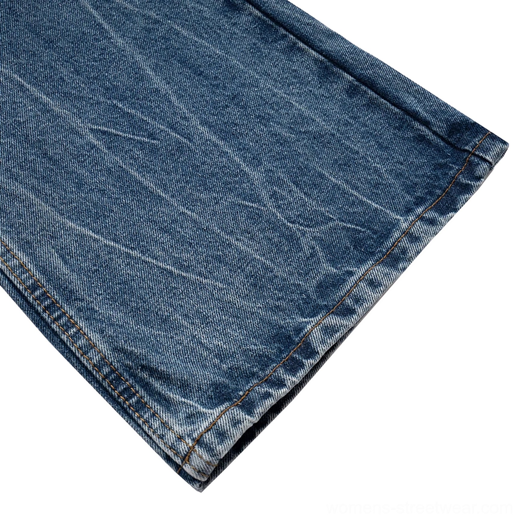 Detailed view of raw frayed hem on vintage washed wide-leg denim jeans with contrast seam stitching and crinkled blue denim texture