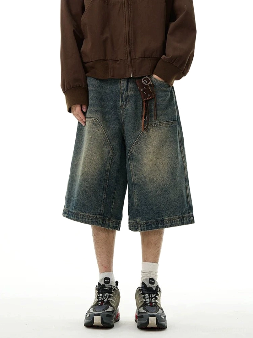 Front full-body view of blue vintage wide-leg denim Bermuda shorts with relaxed fit, oversized patch pockets, washed denim finish, and streetwear styling