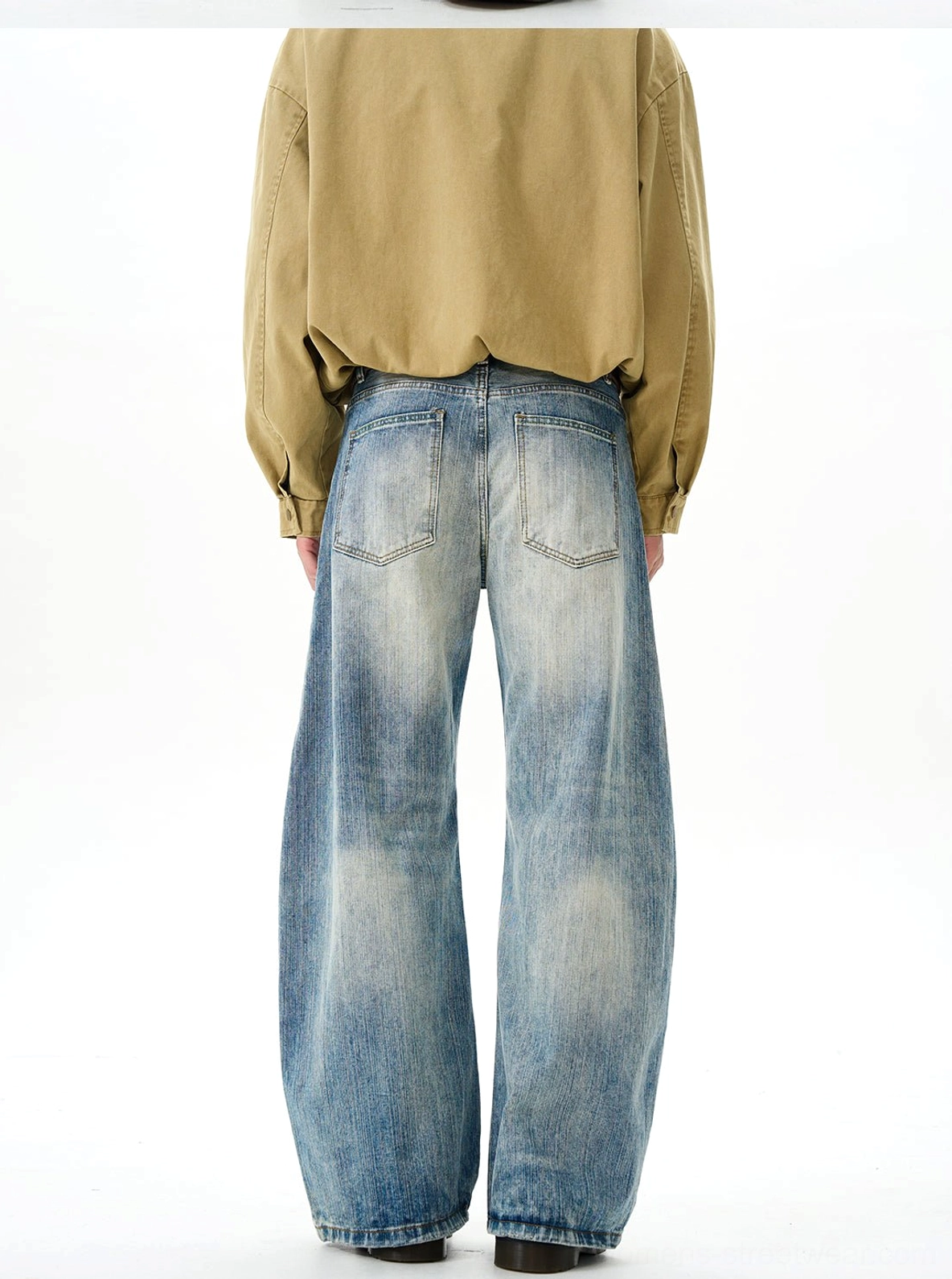 Back view of vintage wide-leg denim jeans showing the classic rear pockets, relaxed wide hem, and faded blue wash styled with a yellow shirt