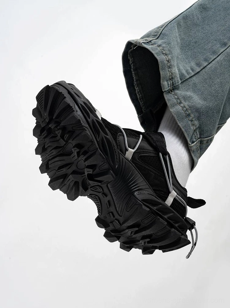 All black tech trail sneakers shown from the bottom side with a matte mesh upper, visible sock liner, thick platform-inspired midsole, and ultra deep rugged outsole
