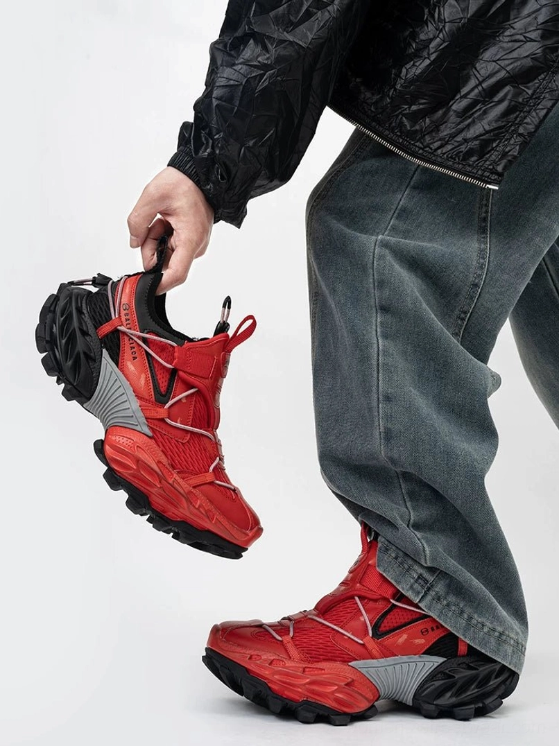 Red black and grey tech trail sneakers featuring a bold red mesh upper, grey heel counter, utility strap details, and deep anti-slip lugged rubber outsole for gorpcore streetwear styling