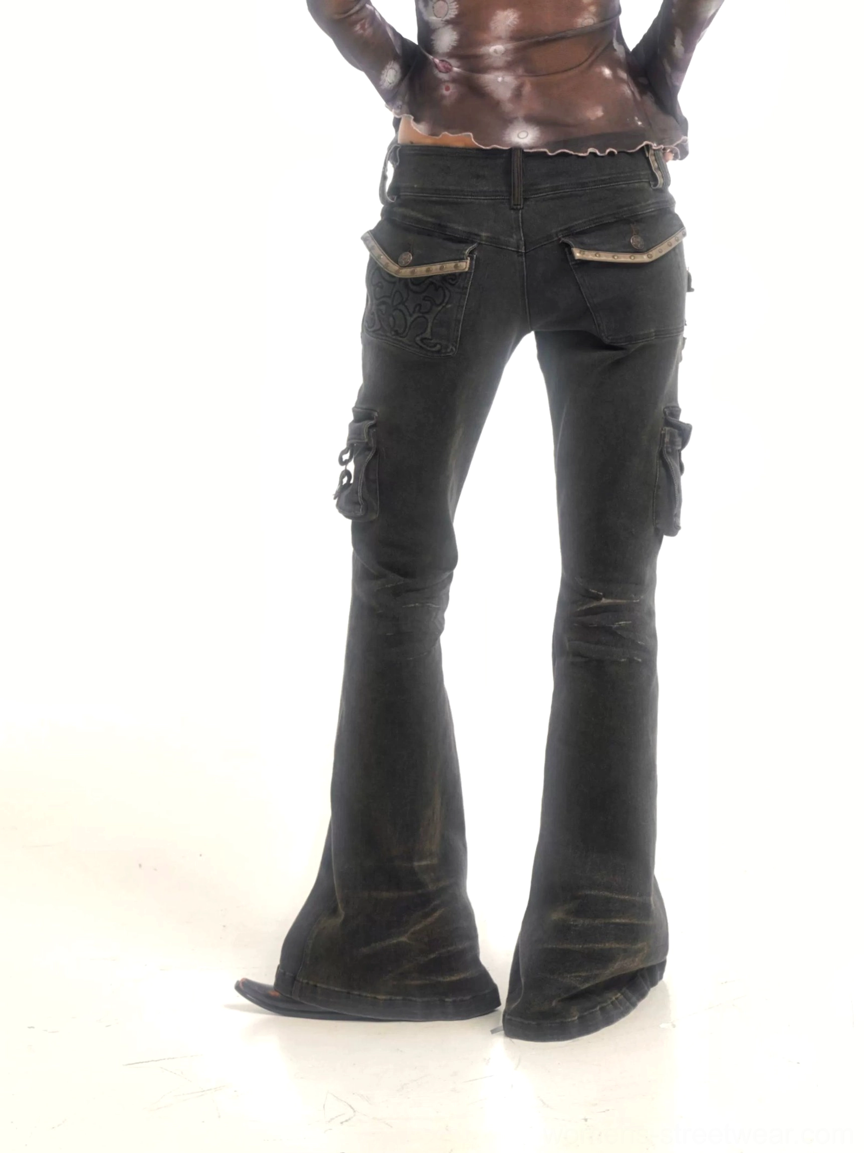 Close-up product view of washed black cargo flare jeans showing front button closure, faded denim texture, utility side pockets, and flared hems