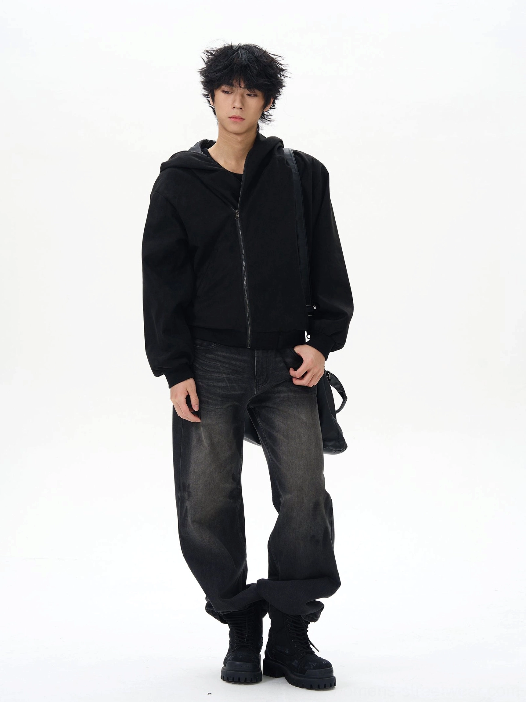 Front view of relaxed washed black loose jeans styled with a crossbody bag and rolled cuffs for a modern Korean streetwear outfit