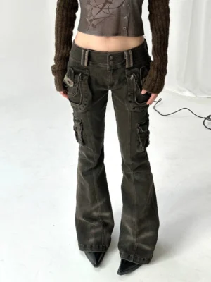Front full-body view of low-rise washed black cargo flare jeans styled with a cropped knit top and pointed-toe boots in a Y2K streetwear outfit