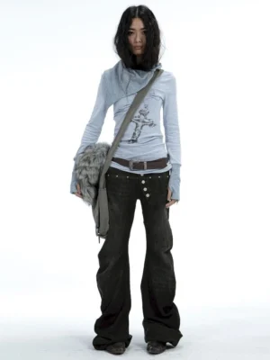 Full-body front view of women’s washed black Y2K low-rise flare jeans styled with a cross graphic top