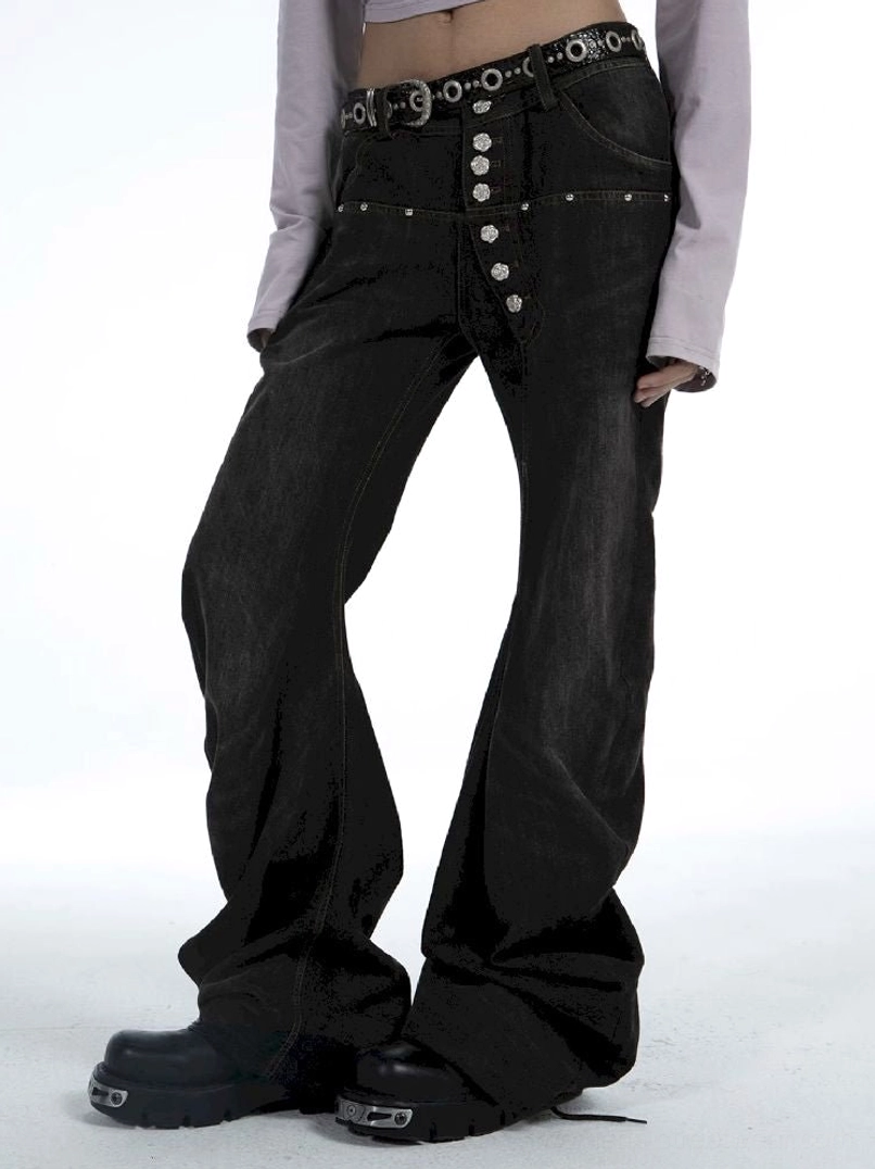 Side close-up of washed black flare jeans with silver button fly metal ring waistband details and platform boots