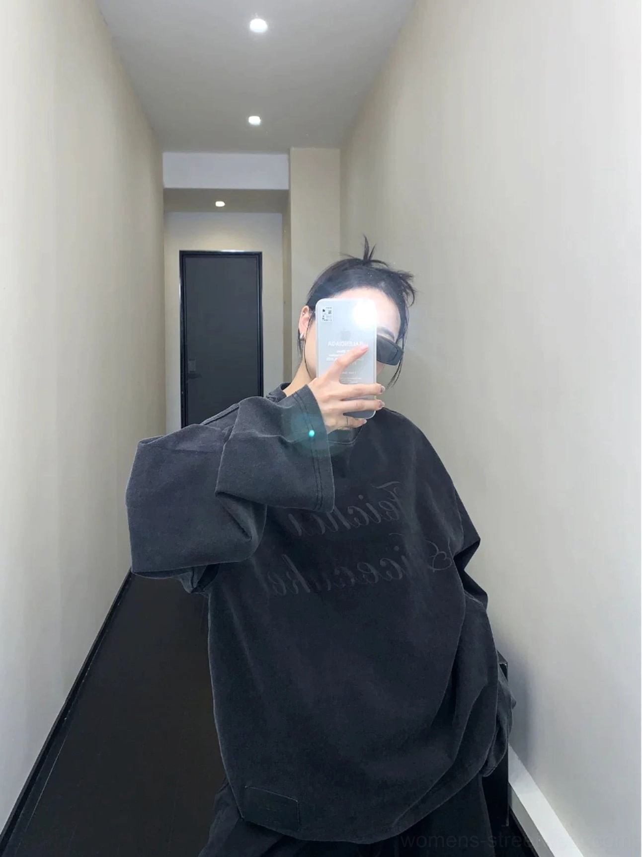 Rear view of a washed black oversized boyfriend-fit crewneck sweatshirt showing its clean solid back and long dropped sleeves