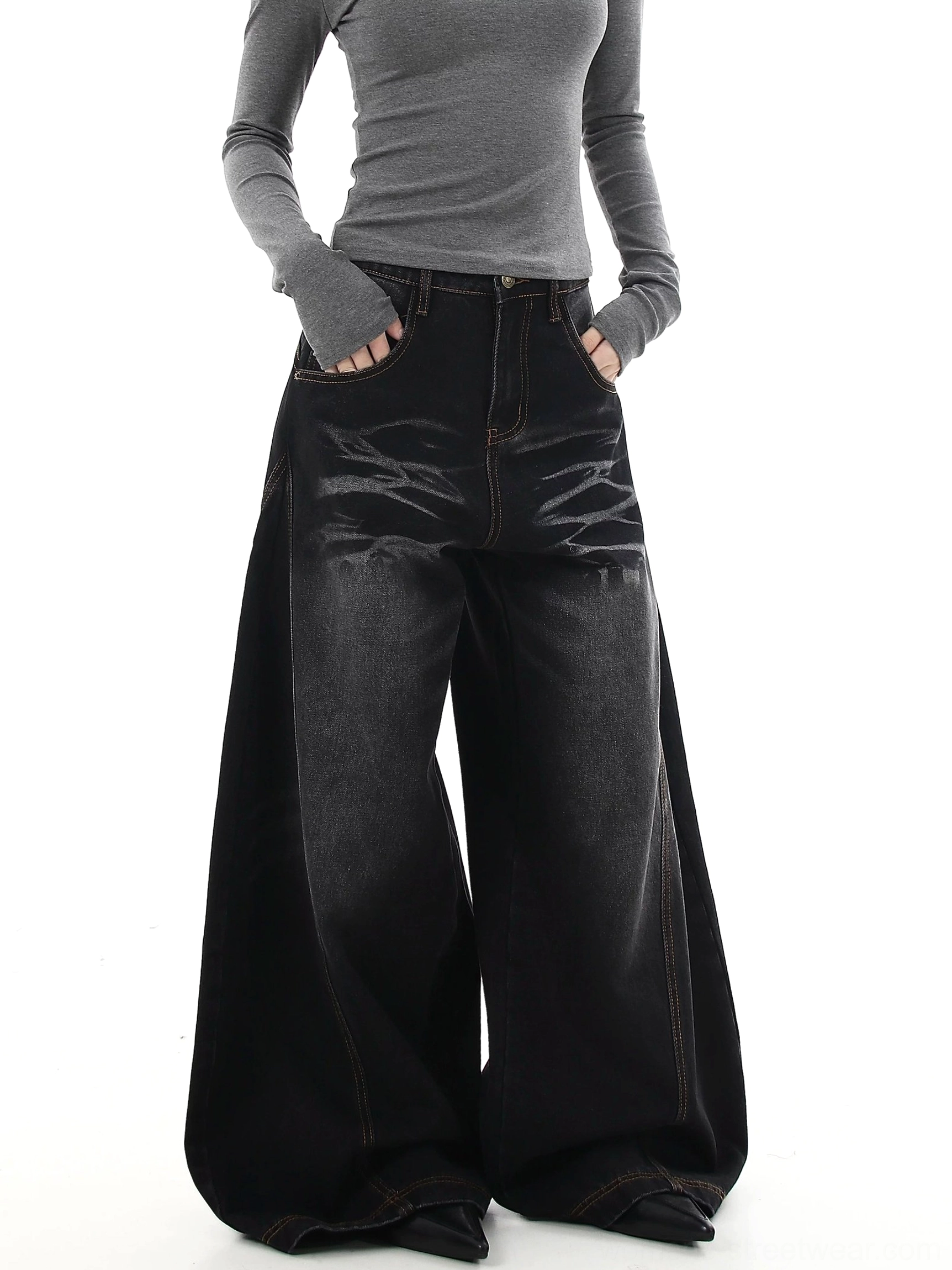 Front view of washed black oversized flare jeans with extra-wide side panels, contrast topstitching, and architectural streetwear proportions