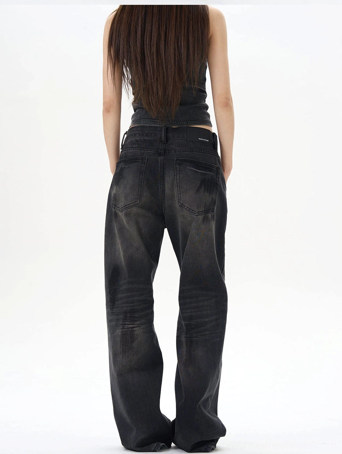 Back view of washed black straight loose jeans showing classic patch pockets, faded rear denim panels, and relaxed wide-leg shape
