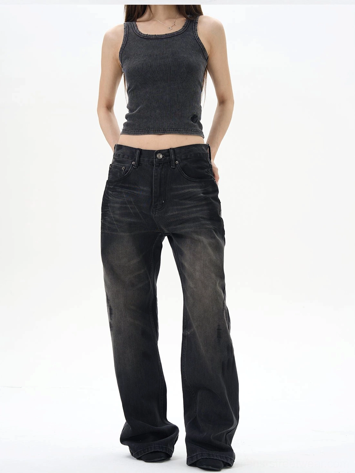 Female model wearing washed black straight loose jeans with a cropped tank top, highlighting the high-waisted relaxed streetwear silhouette