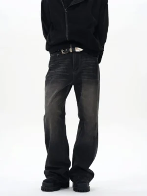 Front full-body view of washed black straight loose jeans with vintage faded denim finish on a male model in a minimalist white studio