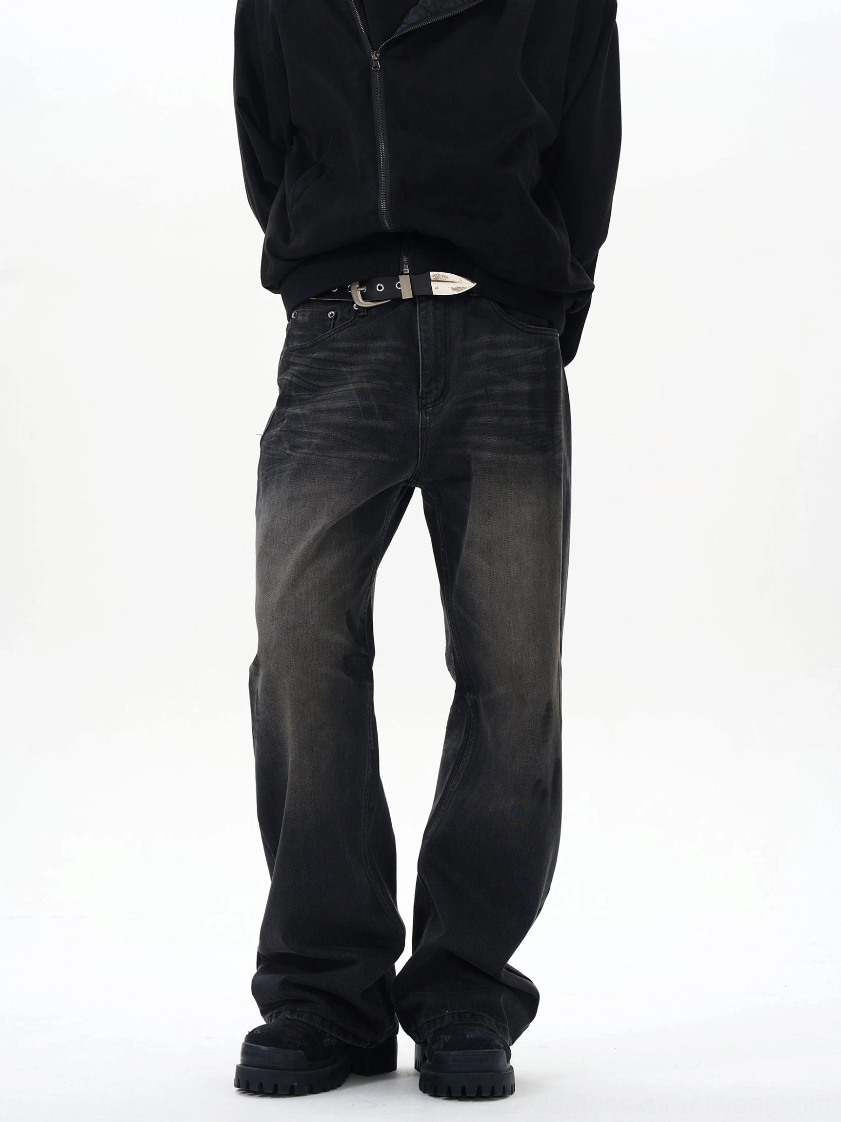 Front full-body view of washed black straight loose jeans with vintage faded denim finish on a male model in a minimalist white studio