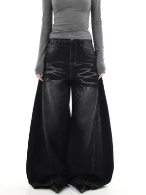 Female model wearing washed black ultra-wide flare jeans with tiger stripe fading and contrast stitching in a modern streetwear outfit