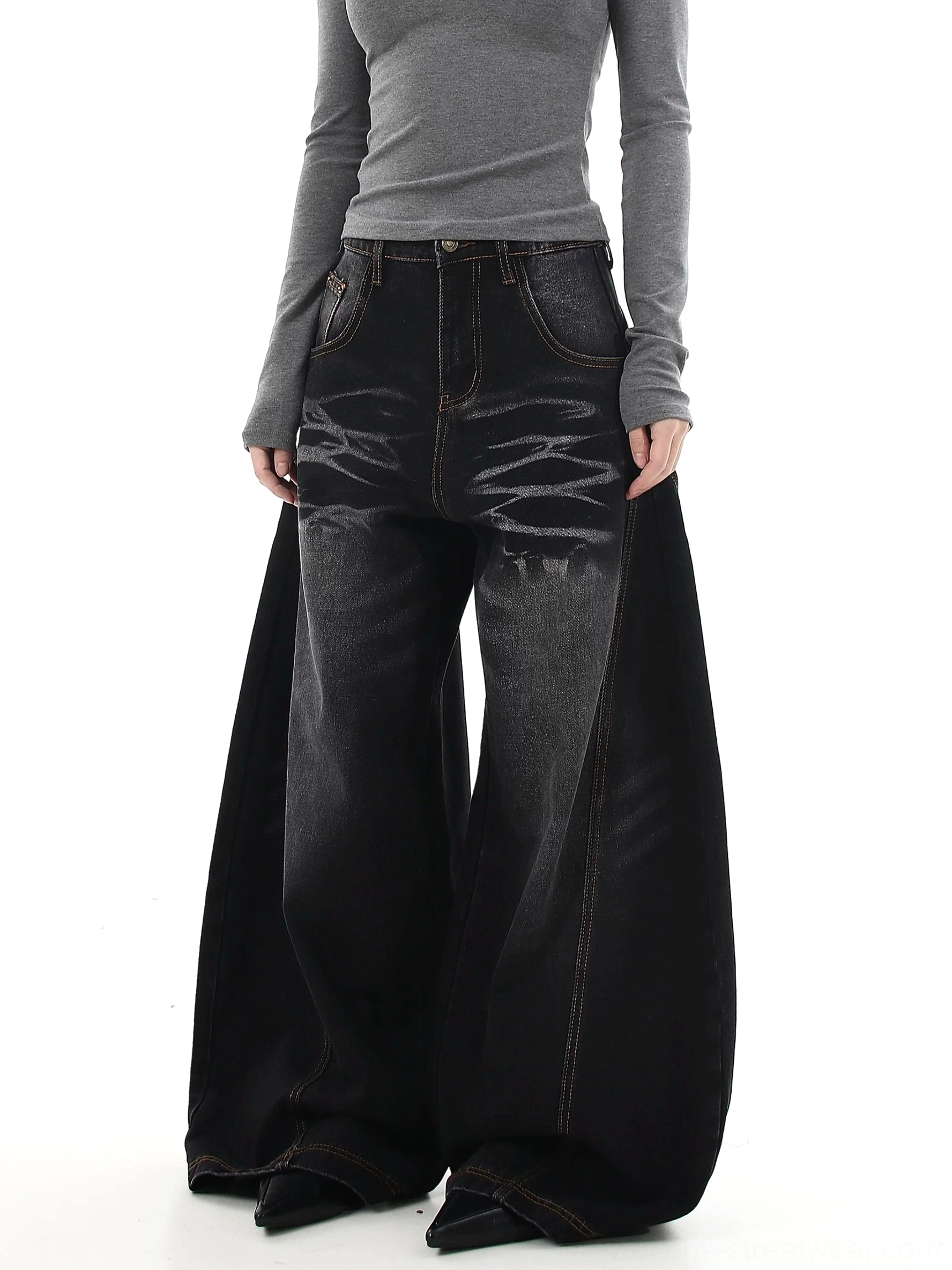 Female model wearing washed black wide-leg denim jeans with dramatic flare, tiger stripe fading, and oversized Seoul street style silhouette