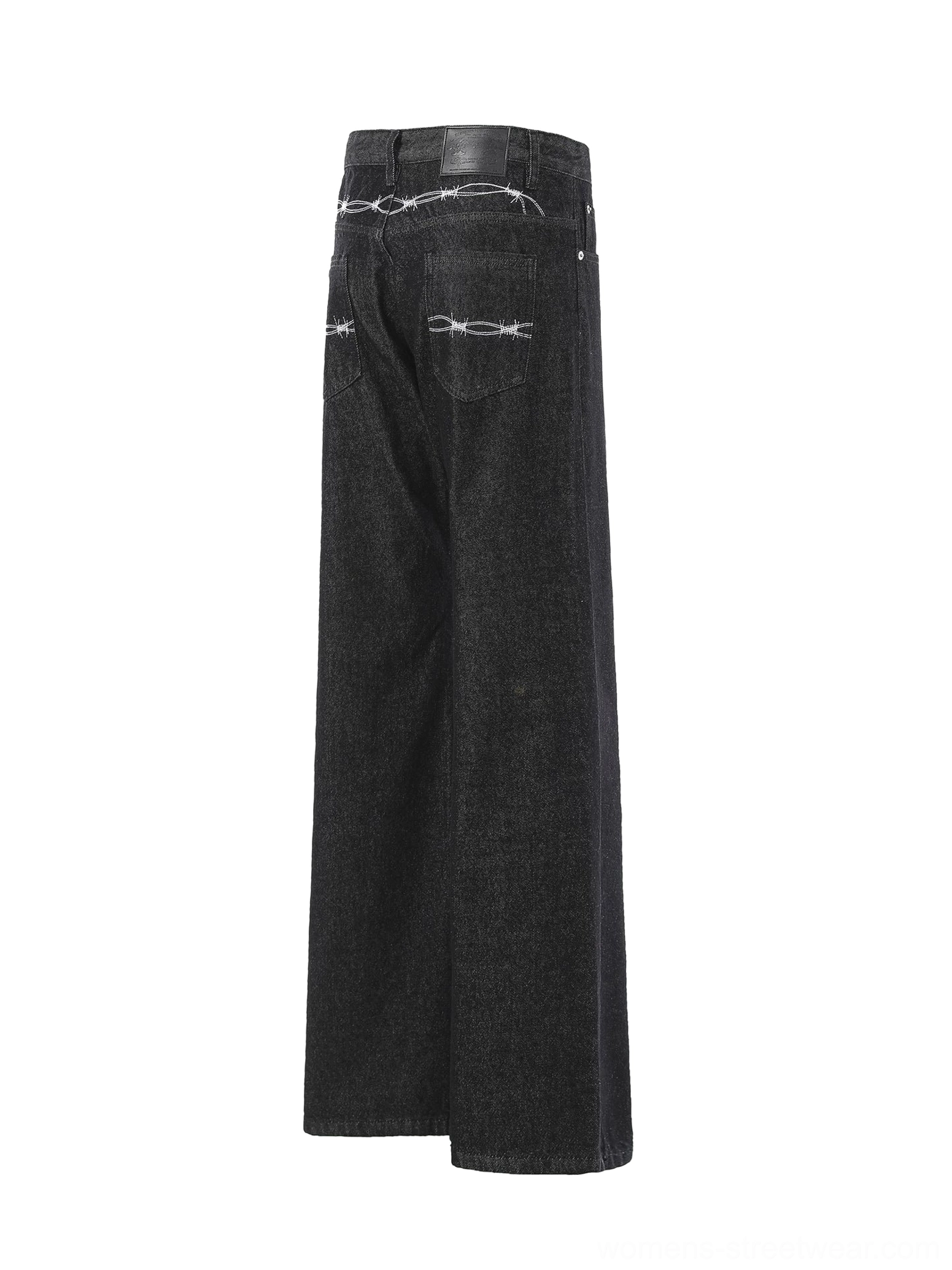 Side rear view of washed black wide leg jeans with barbed wire back embroidery and waistband patch