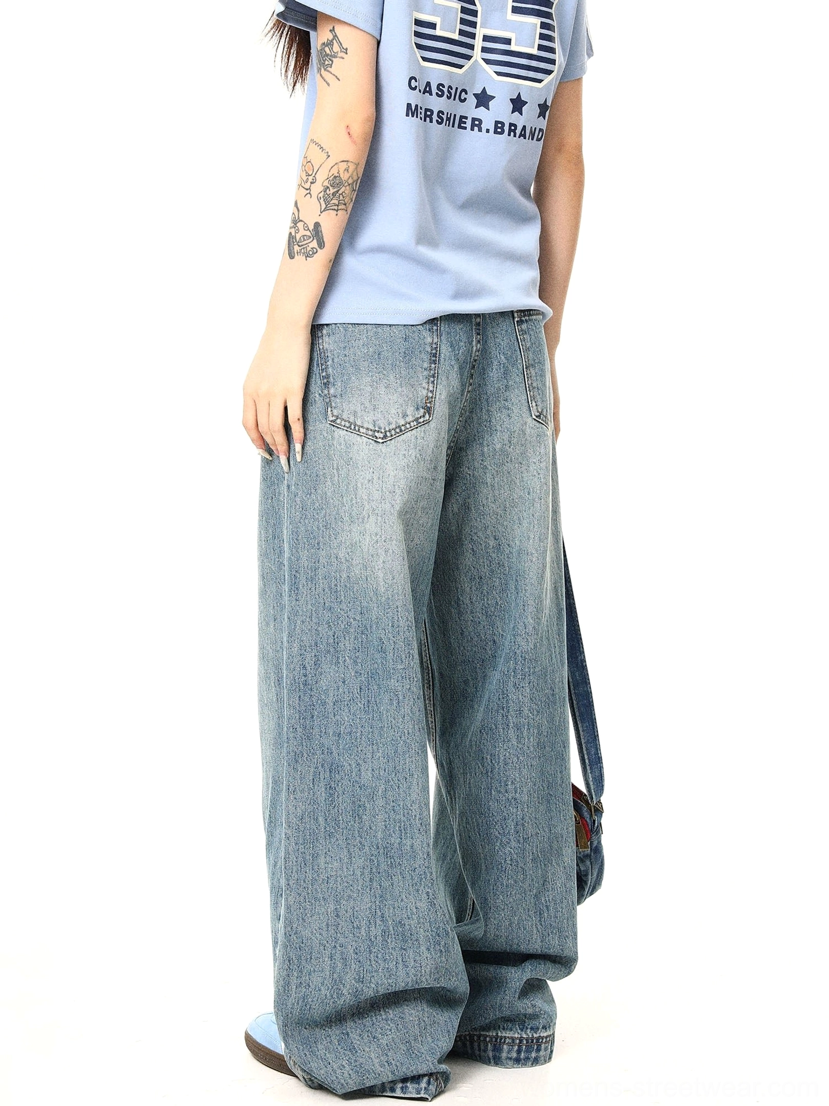 Side-back view of relaxed washed blue baggy jeans showing the wide leg shape, back pockets, and casual denim styling
