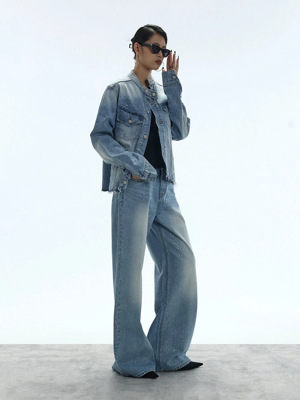 Three-quarter view of a coordinated washed blue glitter denim outfit with wide-leg jeans and a cropped denim jacket