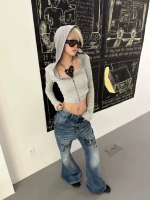 Three quarter view of washed blue graphic flare jeans featuring vintage denim wash, low waist design, and printed pant legs