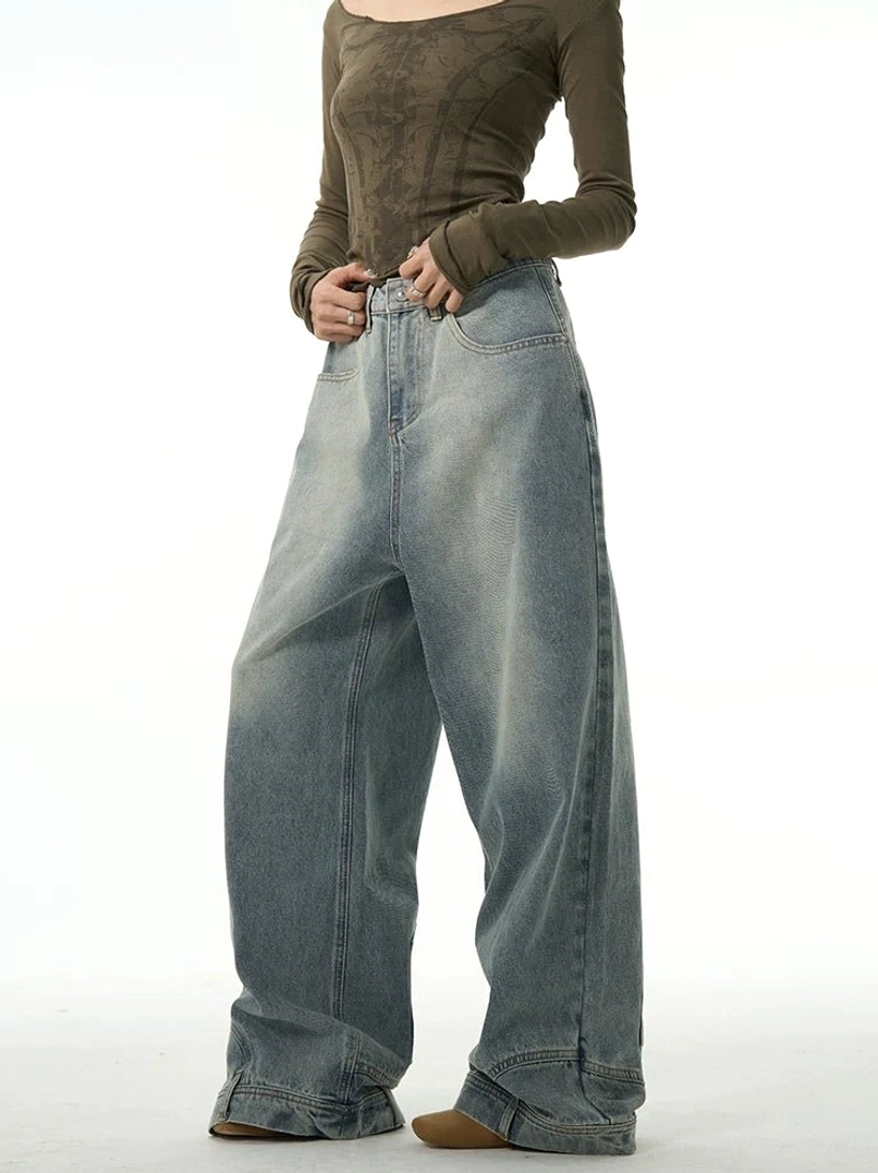 Front full-body view of women’s washed blue inside-out wide-leg jeans with high waist, faded denim panels, layered hems, and relaxed streetwear silhouette