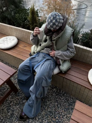 Washed blue streetwear cargo pants shown from above with layered waist straps and a relaxed baggy silhouette