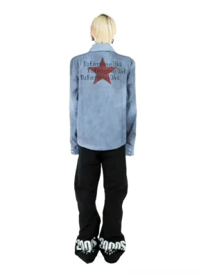 Full back view of a washed blue and white pinstripe graphic work shirt with large red star design, distressed lettering, relaxed boxy fit, and long sleeves styled with black wide-leg streetwear pants