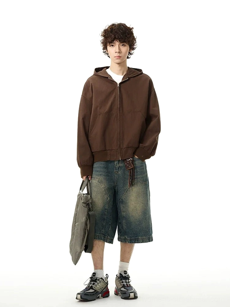 Front view of relaxed fit washed blue wide-leg denim shorts with large patch pockets styled with a hoodie, sneakers, socks, and tote bag