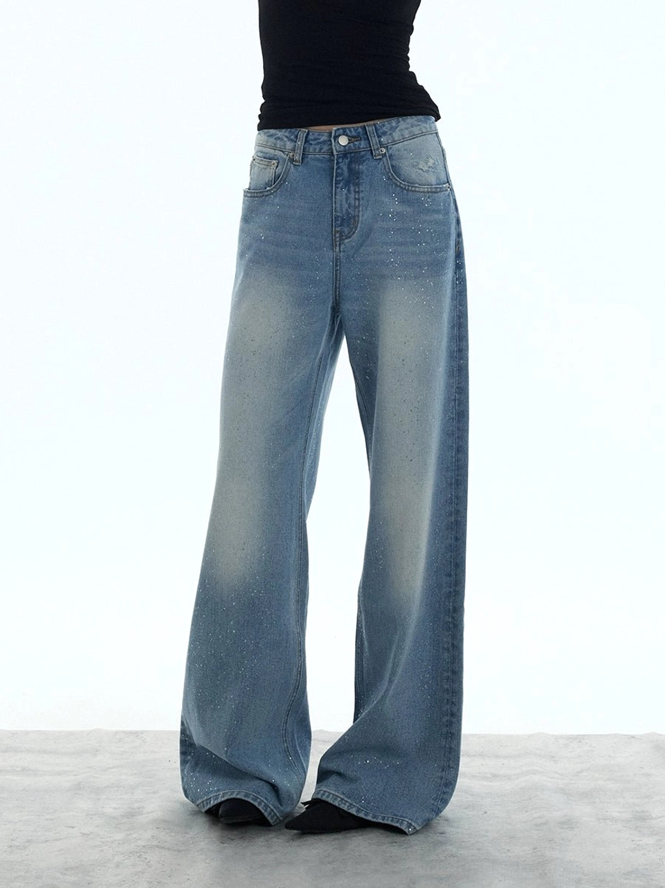 Front view of relaxed washed blue wide-leg jeans with a classic five-pocket silhouette styled for casual streetwear