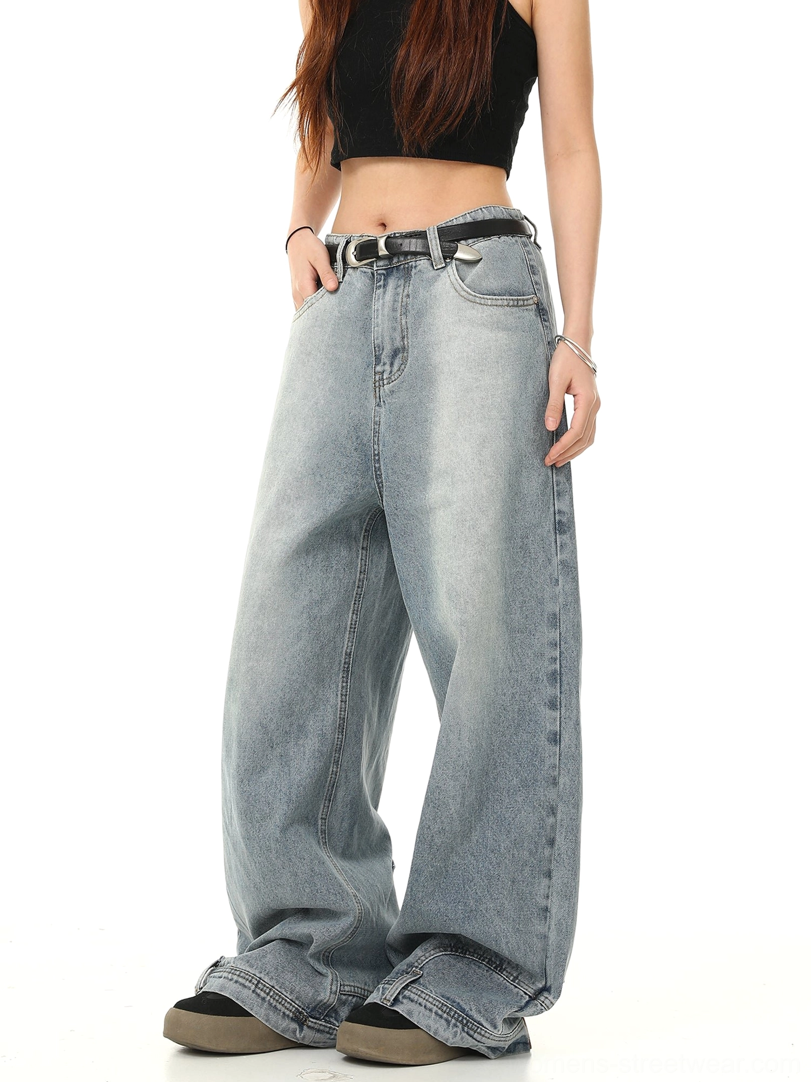 Three-quarter side view of faded blue Y2K wide-leg baggy jeans with extra-volume denim legs, long hem, and casual streetwear styling