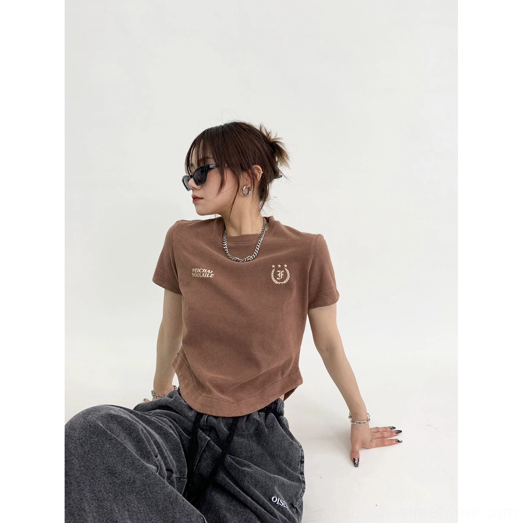 Dark brown washed collegiate logo curved hem streetwear t-shirt seated streetwear outfit view