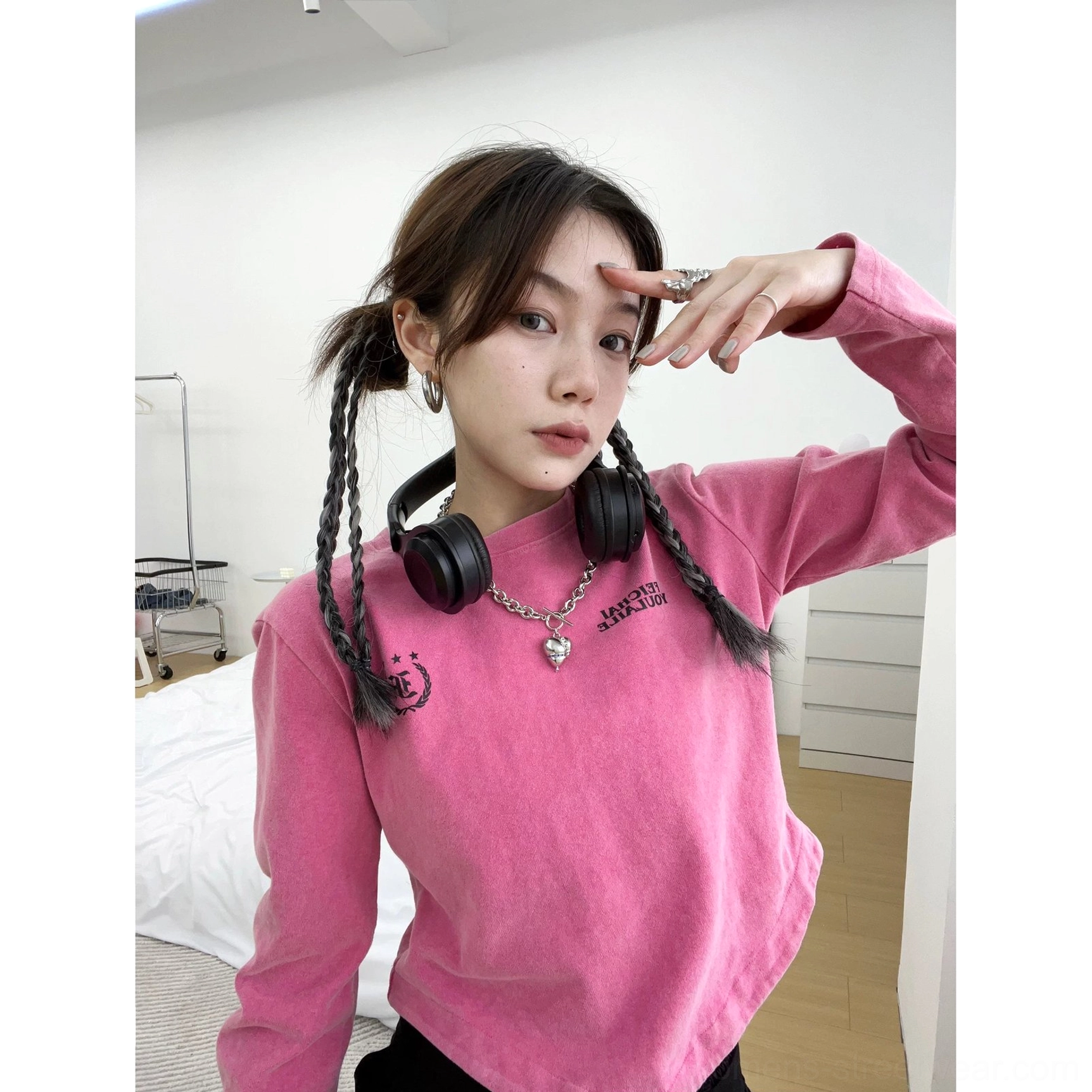 Hot pink washed collegiate logo curved hem streetwear t-shirt styled with headphones and silver necklace