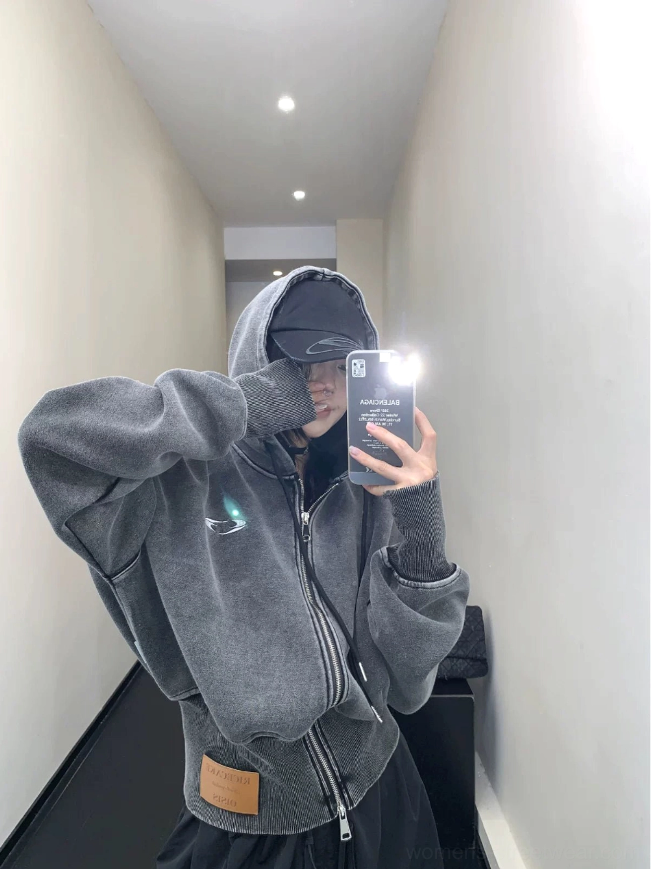 Back view of an oversized vintage washed cropped hoodie in dark gray showing the relaxed boxy fit, cropped waist, and lower hem patch