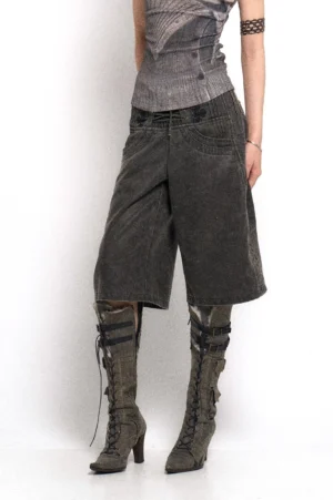 Dark grey washed wide-leg denim culotte pants with high-rise lace-up corset waist, oversized front pockets, and distressed streetwear texture shown in a low-angle studio view
