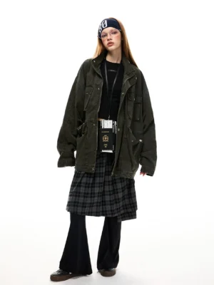Front view of a washed dark olive green oversized cotton utility jacket with loose sleeves, metal buttons, and practical cargo pockets