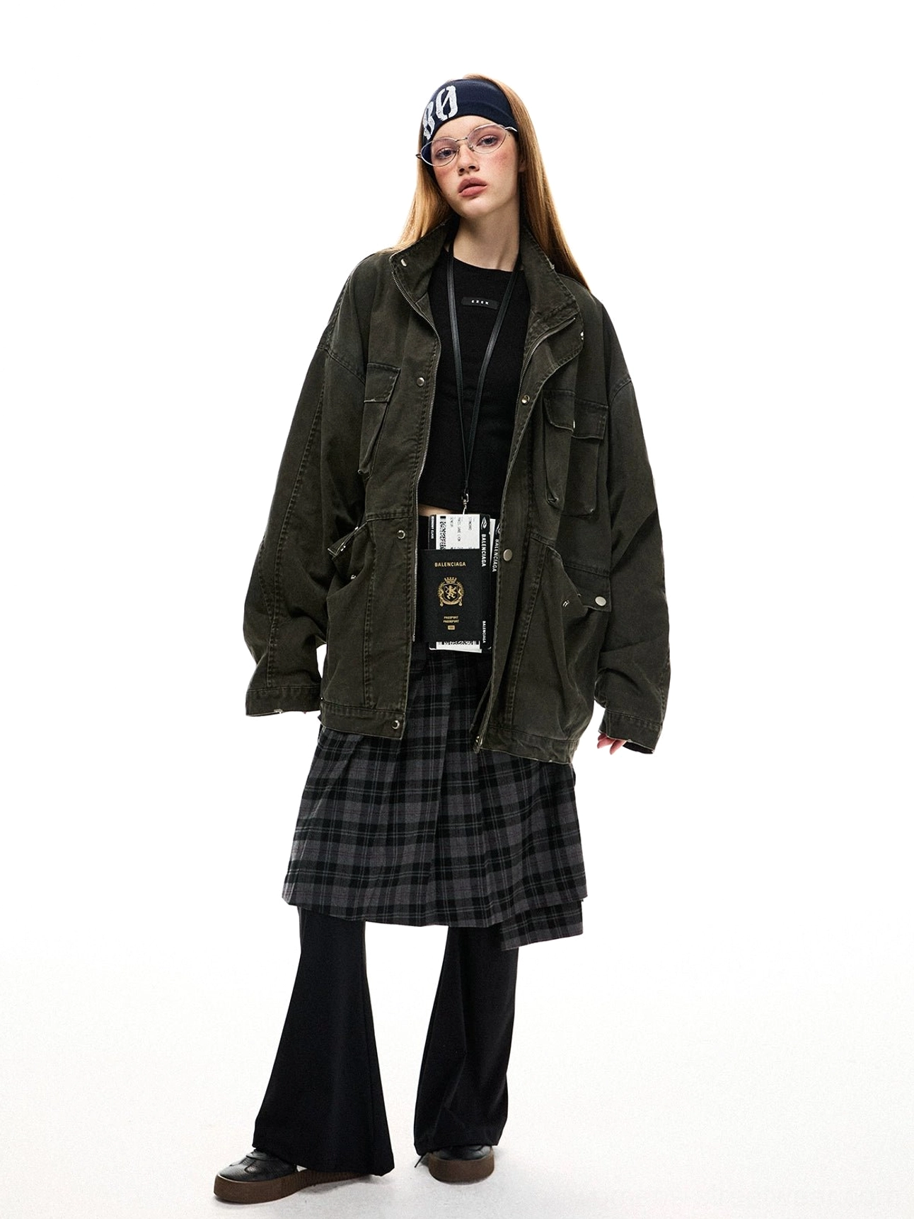 Front view of a washed dark olive green oversized cotton utility jacket with loose sleeves, metal buttons, and practical cargo pockets