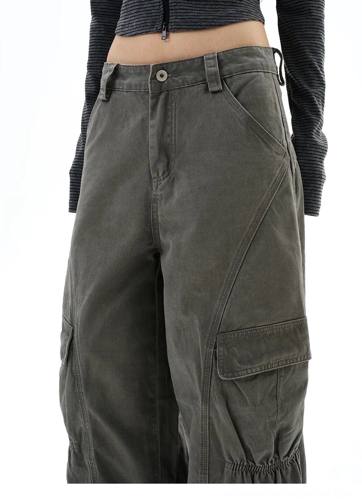 Close-up of washed gray-green cargo pants waistband, front slant pocket, button closure, and ruched side cargo pocket