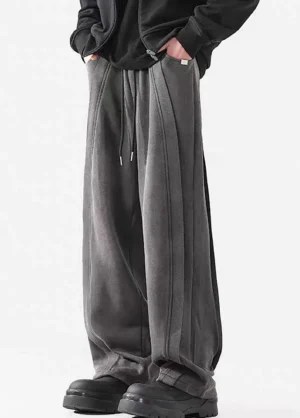 Three-quarter view of washed gray wide-leg streetwear pants with relaxed fit, stacked hem, and chunky black boots