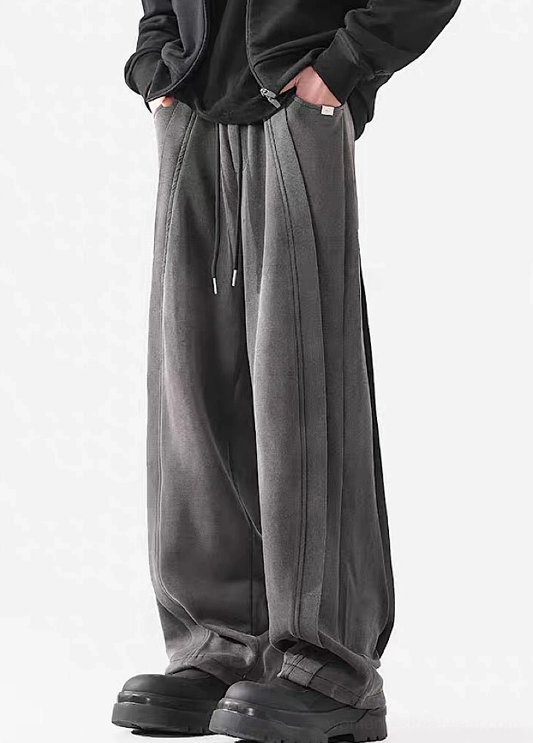 Three-quarter view of washed gray wide-leg streetwear pants with relaxed fit, stacked hem, and chunky black boots