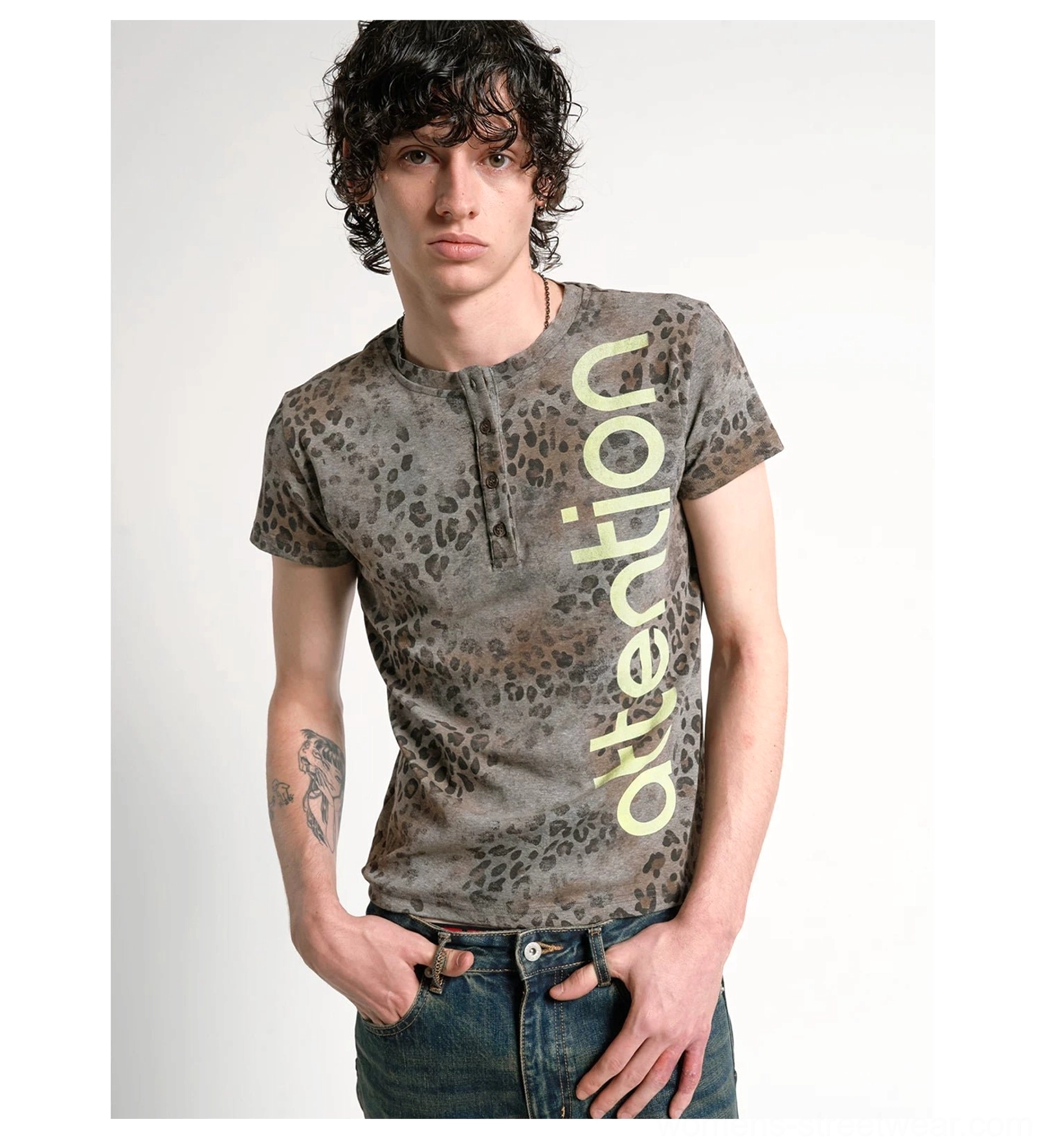 Front full-body view of a washed grey brown leopard Henley tee with lime vertical attention graphic and dark denim styling