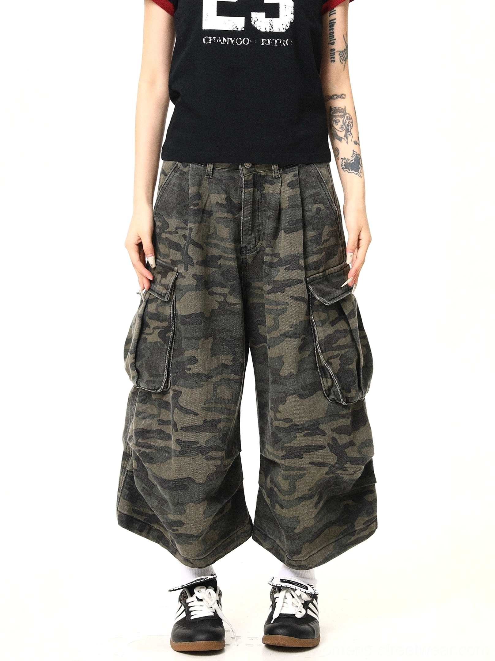 Front view of women’s washed camouflage cargo pants featuring oversized utility pockets, relaxed wide-leg fit, high-waisted pleats, and vintage military green streetwear styling