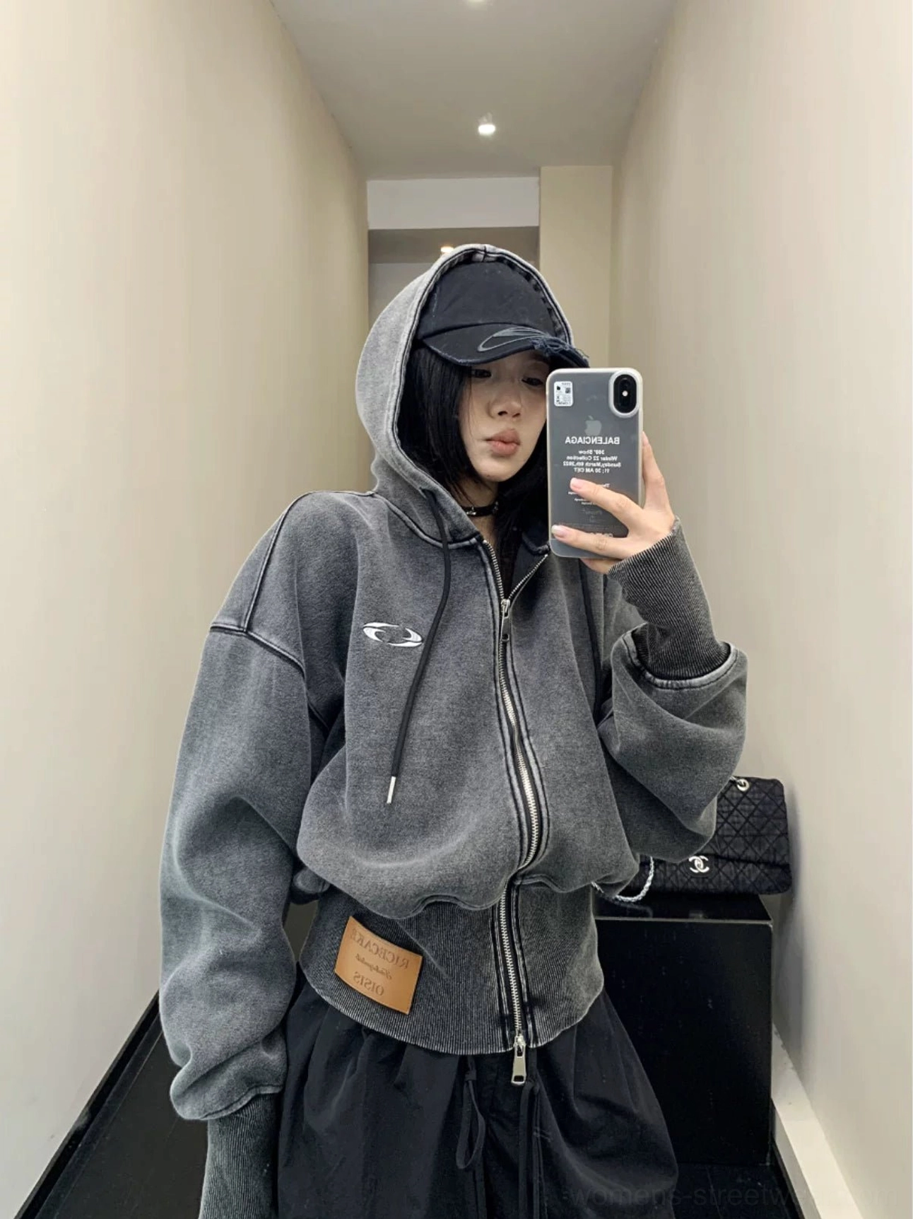 Front mirror view of a vintage washed oversized cropped zip-up hoodie in dark gray with dropped shoulders, chest embroidery, hood, and ribbed hem
