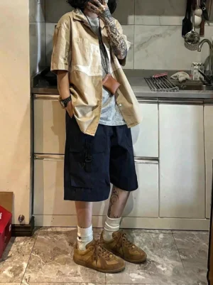 Model wearing tan brown washed suede colorblock retro trainers with black cargo shorts white crew socks and casual streetwear outfit