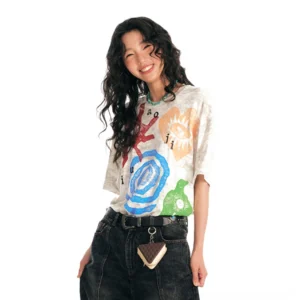 Female model wearing multicolor washed tribal graphic oversized streetwear tee with faded vintage finish on white studio background