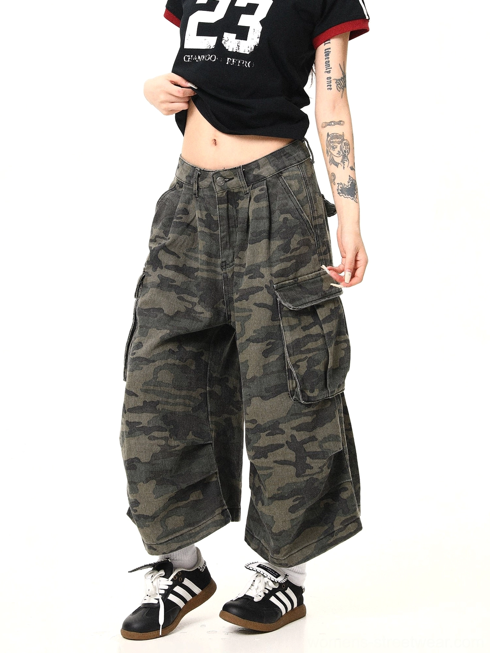 Close front angled view of women wearing washed vintage camouflage cargo pants with a clean high waist, relaxed baggy fit, oversized side pockets, and utility streetwear details