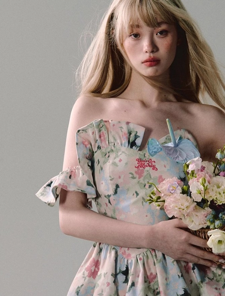 Close-up of a watercolor floral mini dress with removable ruffle sleeves, blue butterfly bodice accent, red chest embroidery, and romantic sweetheart neckline