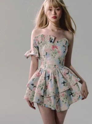 Front full-body view of a white watercolor floral off-shoulder ruffle mini dress with sweetheart neckline, removable sleeves, fitted corset bodice, and layered skirt