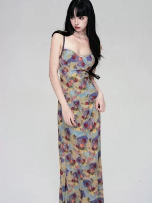 Woman wearing a watercolor floral slip maxi dress with sweetheart neckline, thin spaghetti straps, slim full-length silhouette, and vintage Korean streetwear styling in a minimalist studio