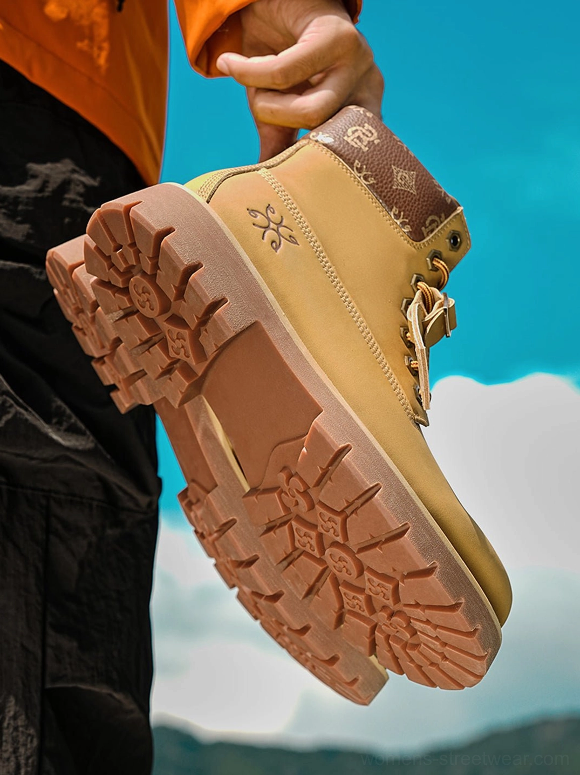 Close-up of wheat contrast-stitch lug sole work boot showing deep rubber tread and textured synthetic upper