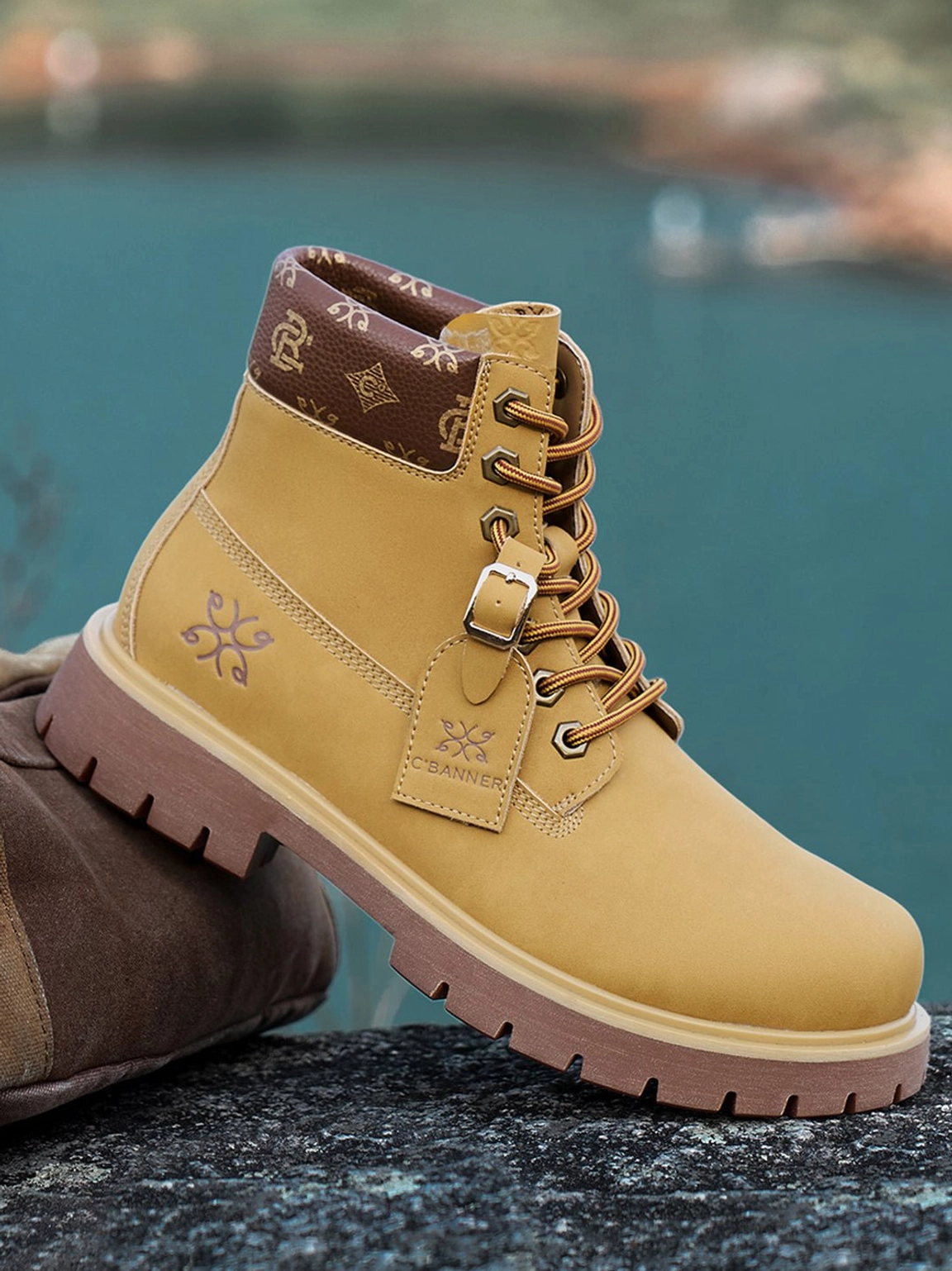 Right side three-quarter view of wheat contrast-stitch lug sole lace-up work boots by a lakeside setting