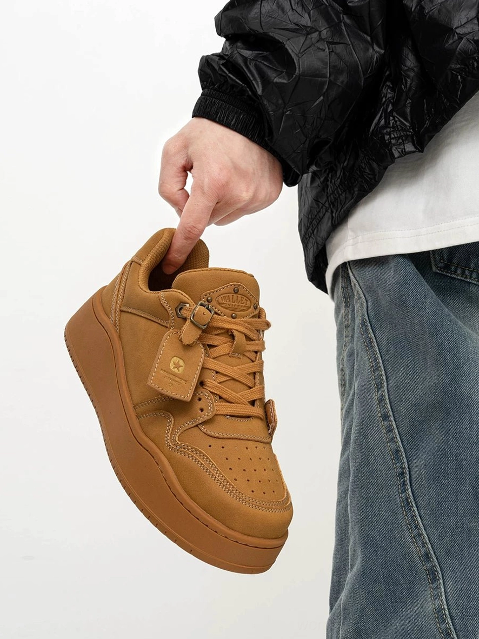 Side close-up of wheat yellow low-top nubuck platform skate sneakers with perforated toe box, wide laces and thick rubber sole